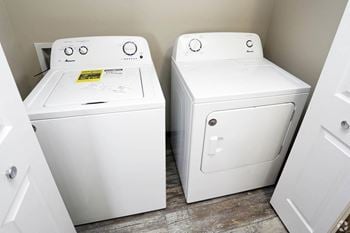 a washer and dryer sit next to each other in a laundry room at Graystone Townhomes, Sioux Falls